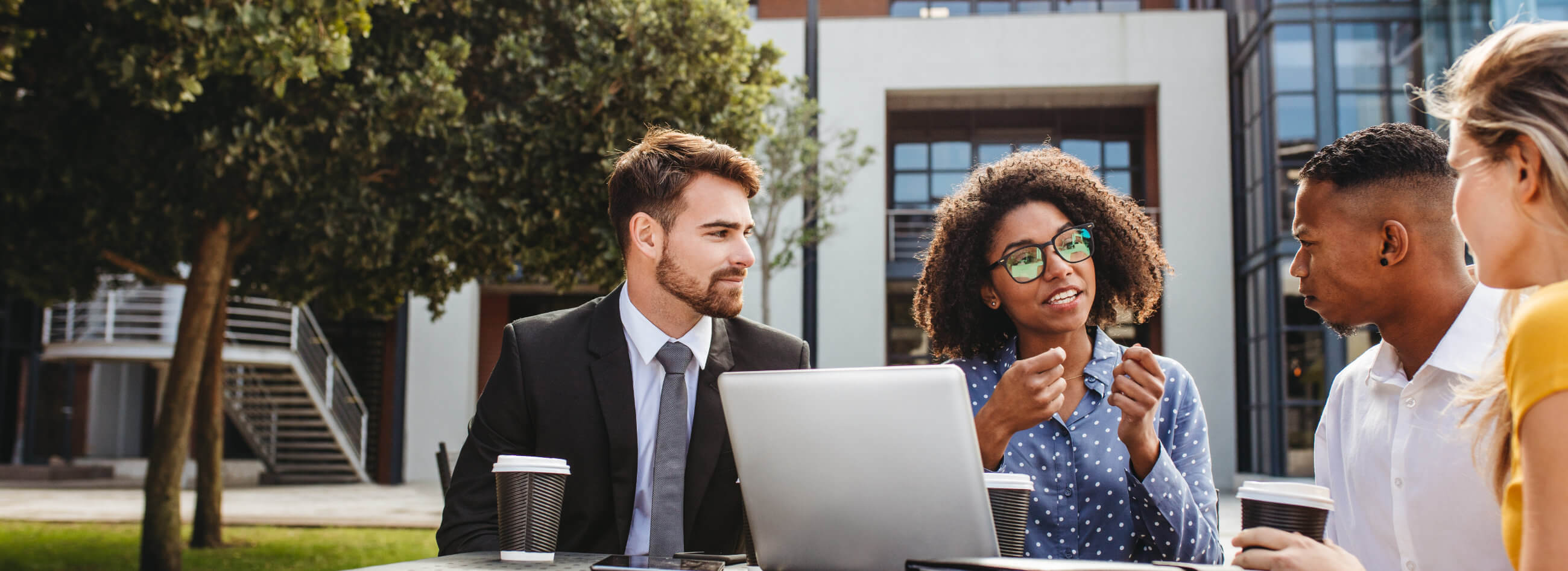 a diverse group of business associates standing in front of a wooden wall